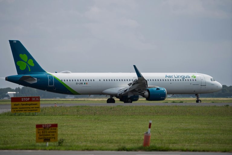 Aer Lingus Airbus A321 taxiing on airport runway in cloudy weather.